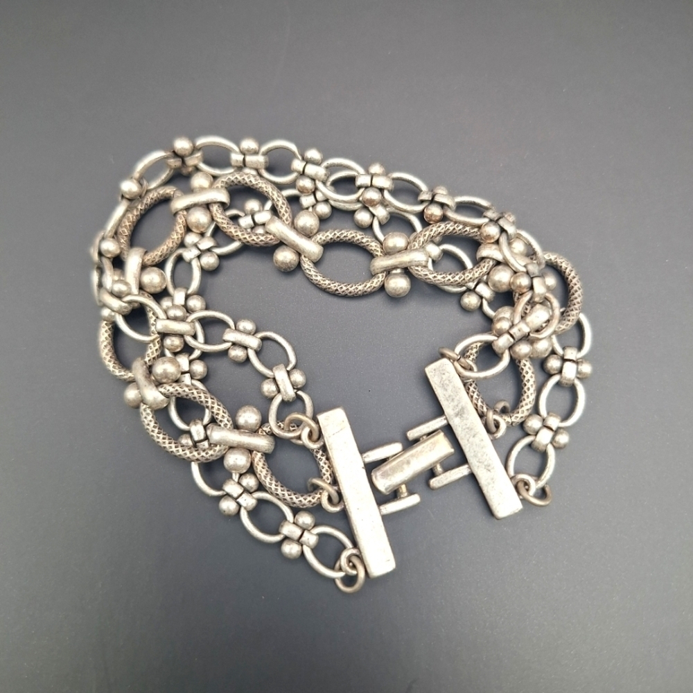 Three strand silver tone bracelet with fold-over clasp, 6.75"